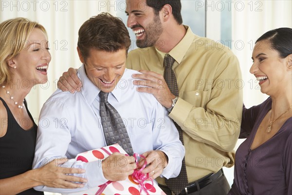 Man with friends opening birthday present