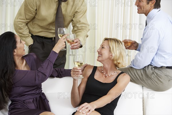 Friends toasting with white wine at party