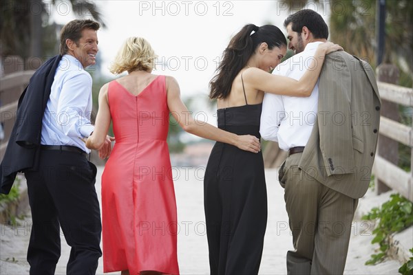 Two elegant couples walking down path together