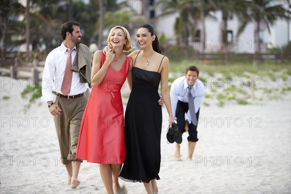 Elegant couples walking on beach together