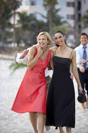 Elegant couples walking on beach together