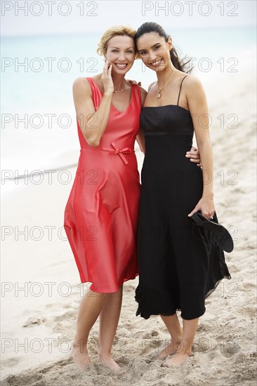 Elegant women standing on beach together