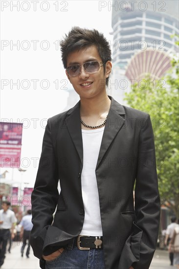 Smiling Chinese man standing outdoors