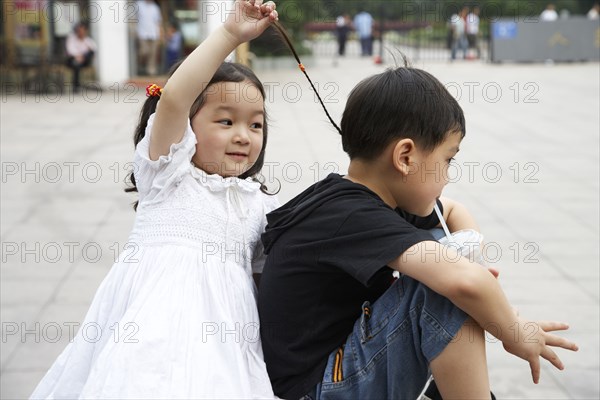 Chinese sister pulling brothers hair