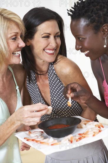 Friends eating shrimp together at party