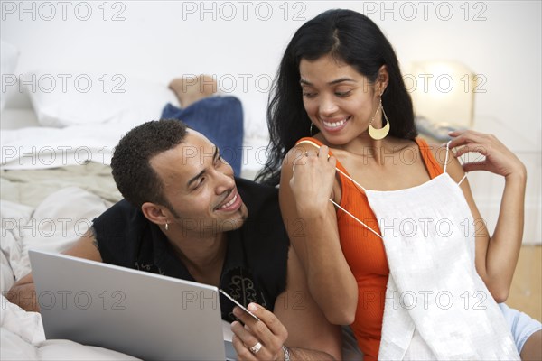 Hispanic woman showing lingerie to husband