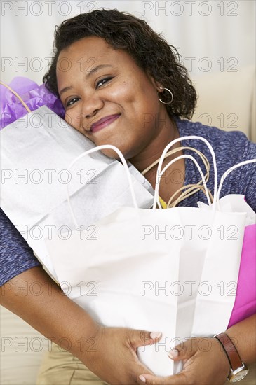 African American woman hugging shopping bags