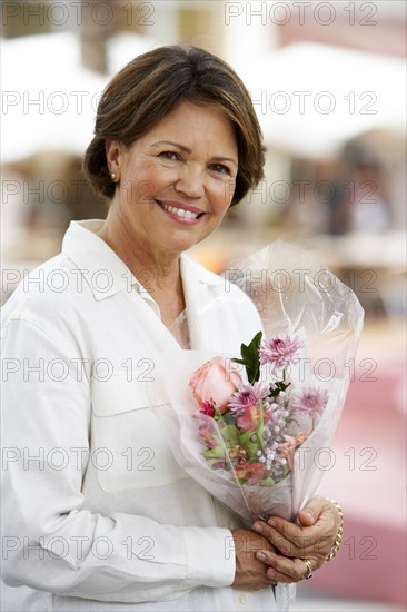 Hispanic woman holding flower bouquet