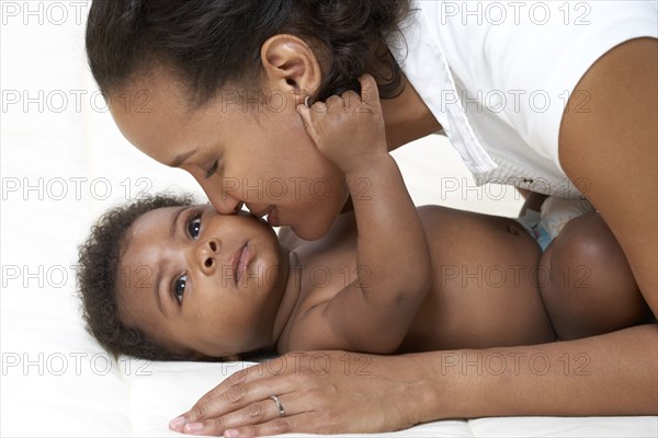 African American mother kissing baby