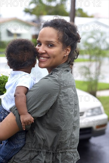 African American mother carrying baby