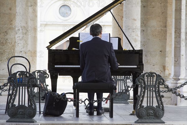 Pianist playing piano outdoors