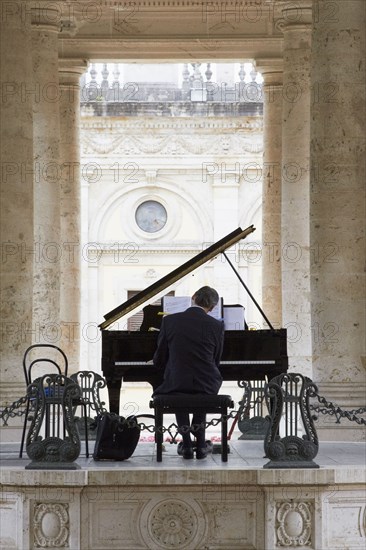 Pianist playing piano outdoors