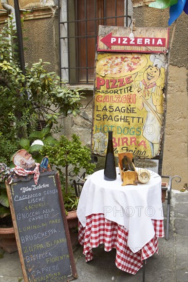 Sign and table outside pizzeria