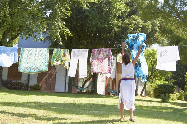 Caucasian woman hanging laundry on clothes line
