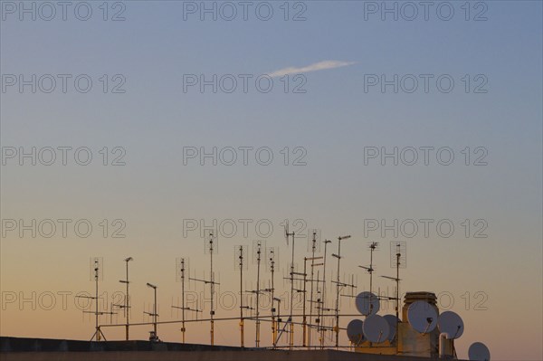 Silhouette of television antennas on rooftop