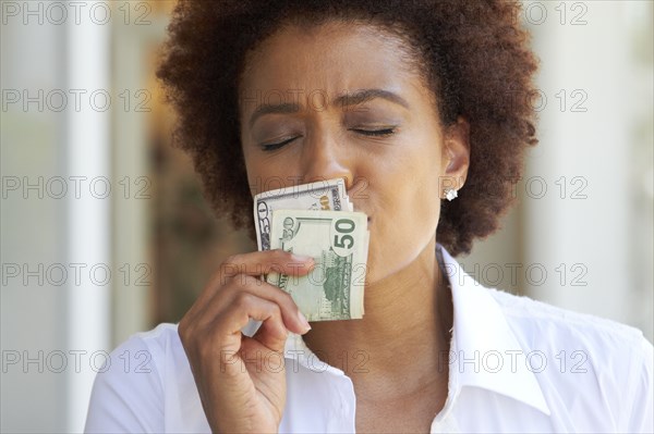 African American woman kissing 50 dollar bill