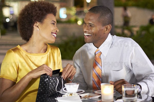 African American giving wife gift over dinner