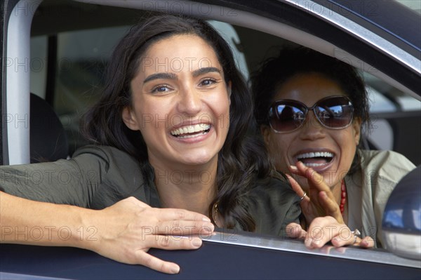 Smiling friends driving in car