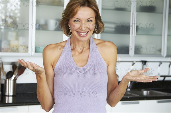 Smiling Caucasian woman standing in kitchen