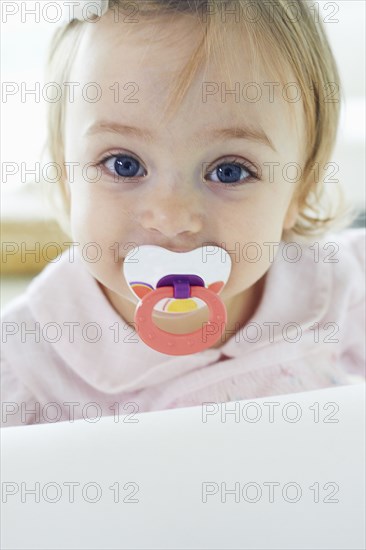 Baby girl sucking pacifier