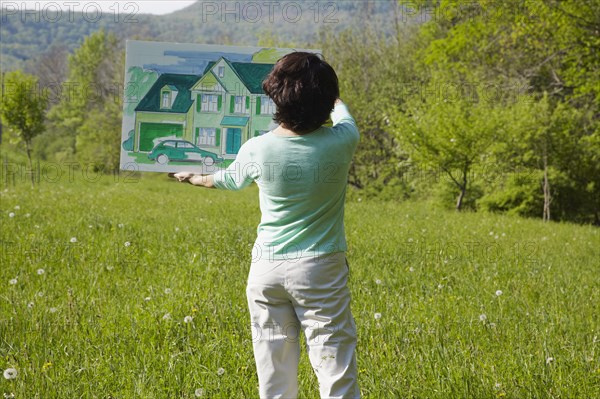 Caucasian woman visualizing house in rural landscape