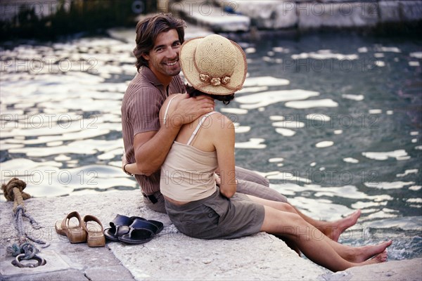 Caucasian couple sitting together by canal