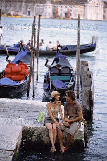 Caucasian sitting together by canal