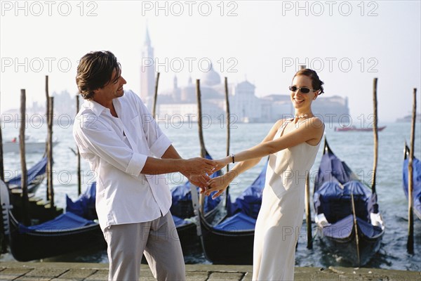 Couple holding hands on urban canal front