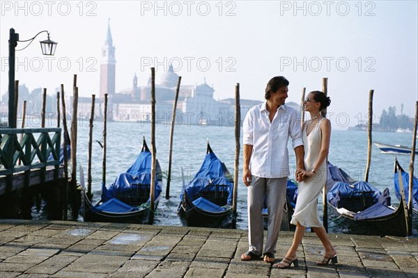 Couple holding hands on urban canal front