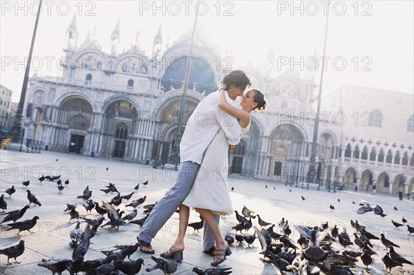Couple surrounded by pigeons in St. Mark's Square
