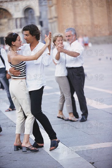 Couples dancing in town square