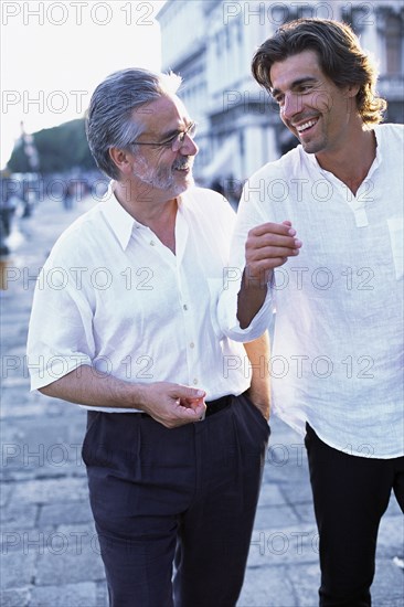 Father and son walking on city street