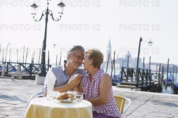 Senior couple eating at sidewalk cafe