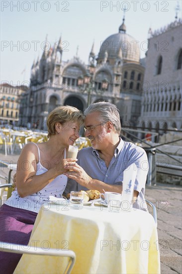 Senior couple eating at sidewalk cafe