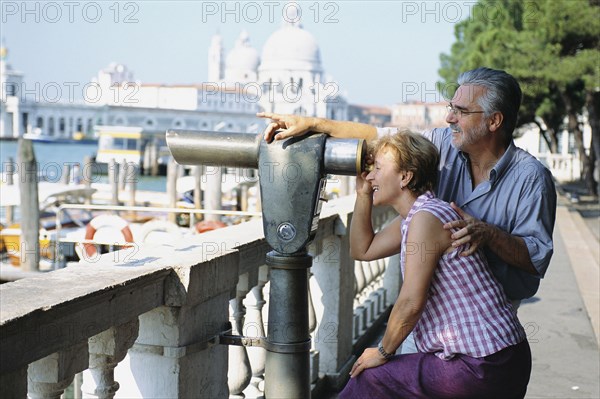 Senior couple looking through telescope