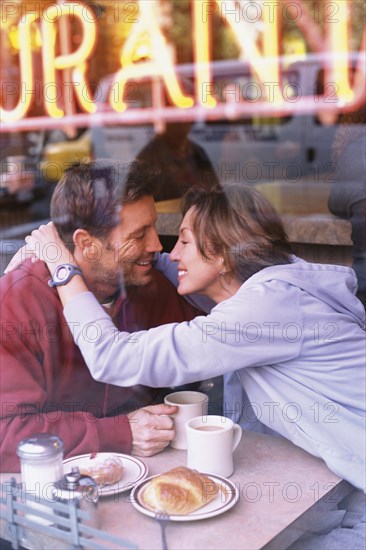 Couple hugging in diner