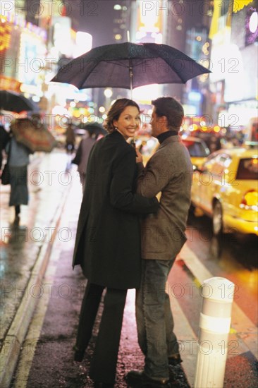 Couple walking on city street at night