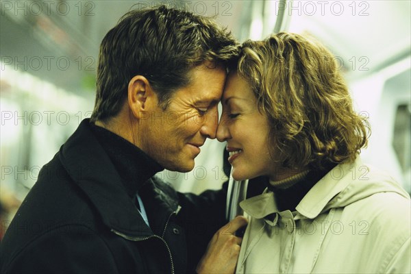 Couple touching foreheads on subway