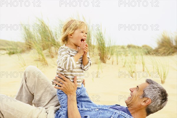 Caucasian father and son playing on beach
