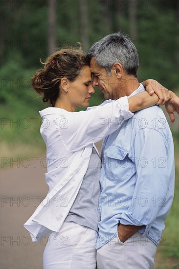 Caucasian couple hugging in park