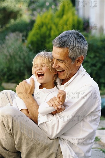 Caucasian father and son hugging outdoors