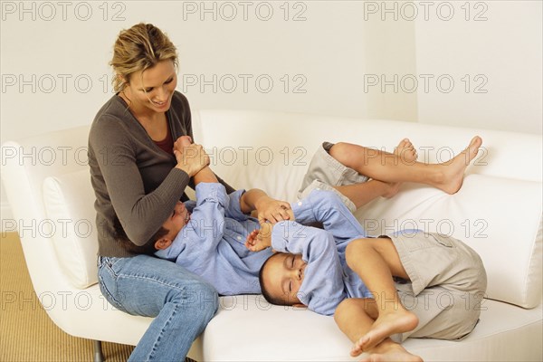 Mother and children playing on sofa