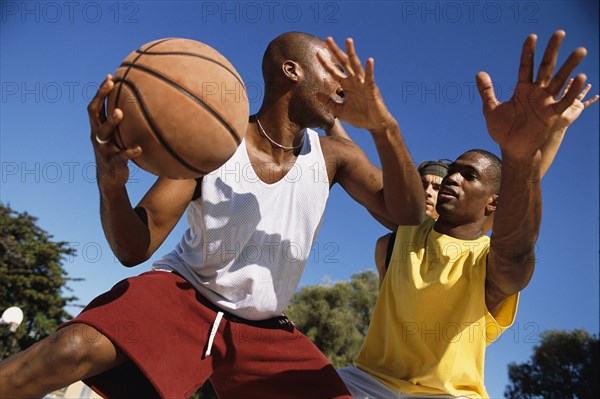 Men playing basketball outdoors