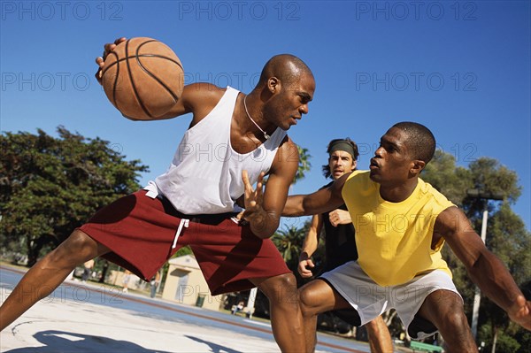 Men playing basketball outdoors