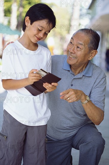 Senior man giving grandson money