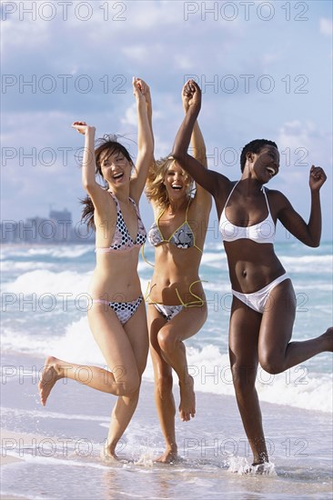 Women jumping for joy on beach