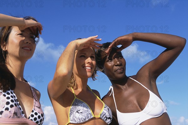 Women shielding their eyes on beach