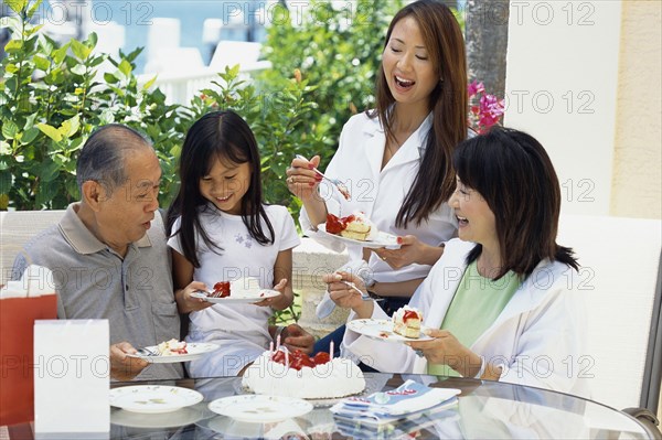 Family eating cake together at birthday