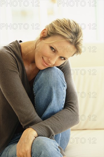 Smiling woman sitting on sofa