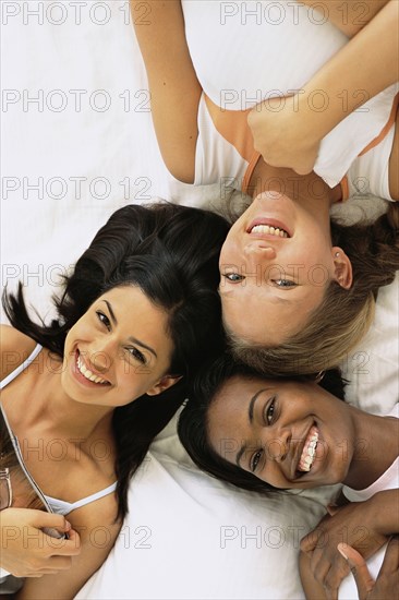 Women relaxing together on bed